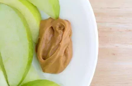 © Bert Folsom | Dreamstime.com - Green apple slices on dish with peanut butter table top